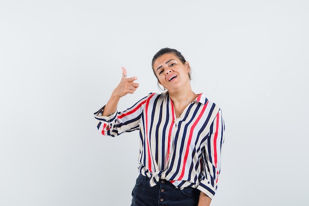 Foto grátis mulher apontando para a frente de camisa, saia e parecendo confiante