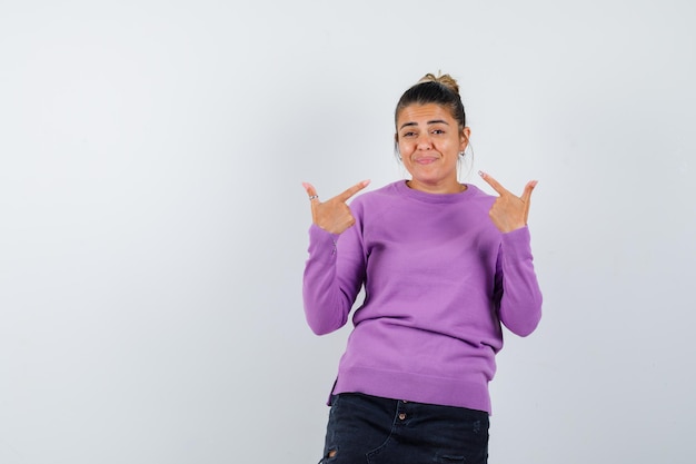 Mulher apontando para si mesma com uma blusa de lã e parecendo confiante