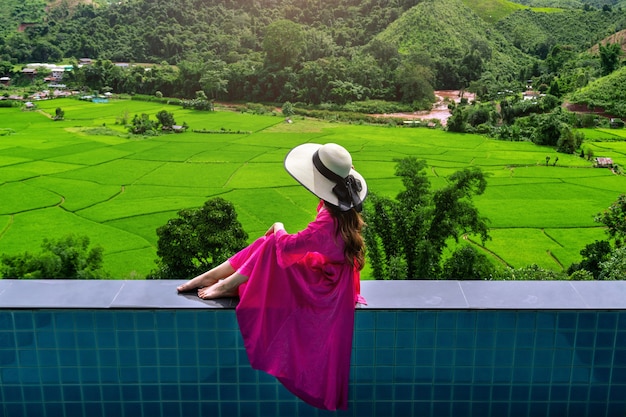 Mulher apreciando o mirante do terraço de arroz e a floresta verde em nan, tailândia