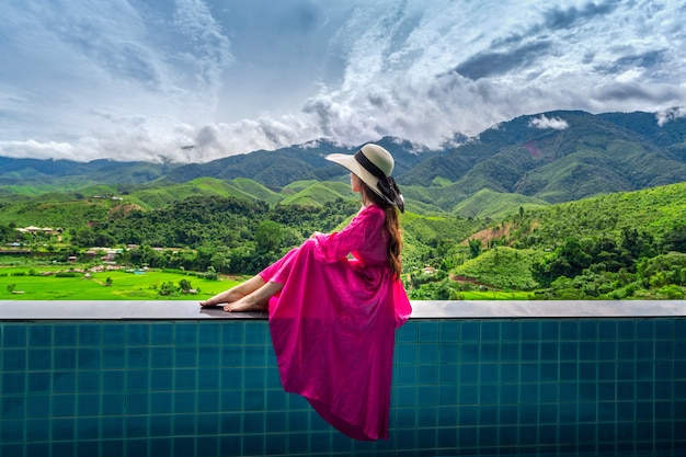 Mulher apreciando o mirante do terraço de arroz e a floresta verde em nan, tailândia
