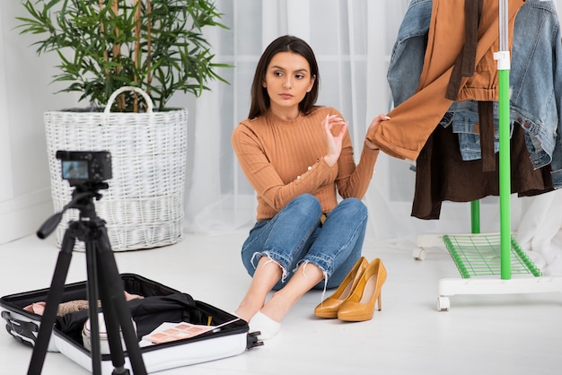 Foto grátis mulher apresentando novas roupas na câmera