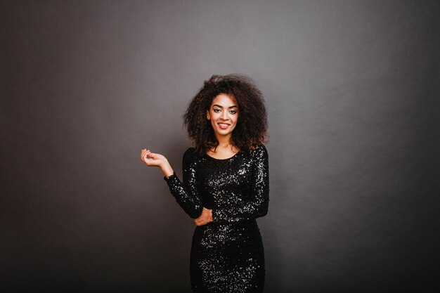 Mulher apta bem vestida com cabelos ondulados sorrindo para a frente