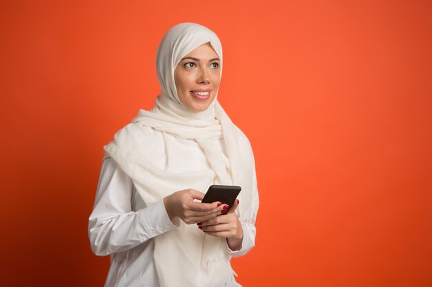 Mulher árabe feliz em hijab com telefone celular.