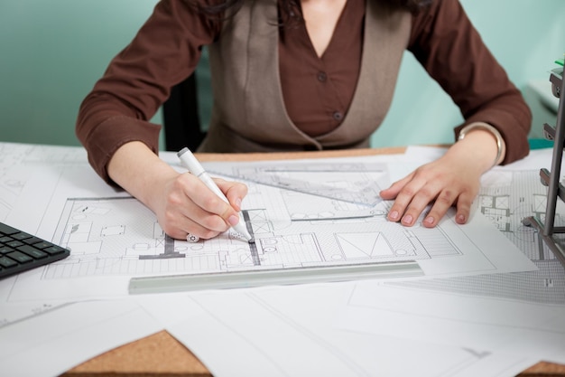 Mulher arquiteta em sua mesa de desenho em plantas. Negócios e criatividade. Trabalho de arquitetura