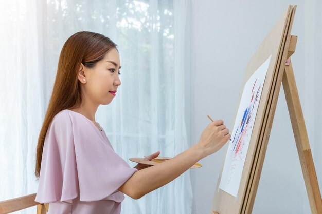 Mulher artista feminina pintando imagens em casa como seu hobby