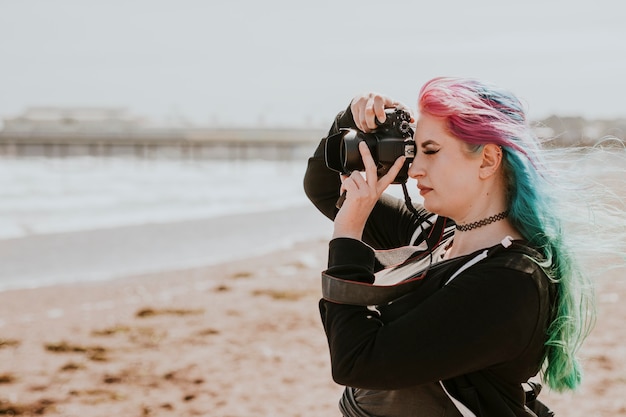 Mulher artística tirando foto em uma praia