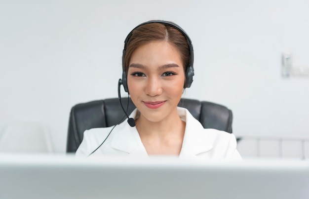 Mulher asiática Agente de call center com fone de ouvido trabalhando na linha direta de suporte no escritório moderno