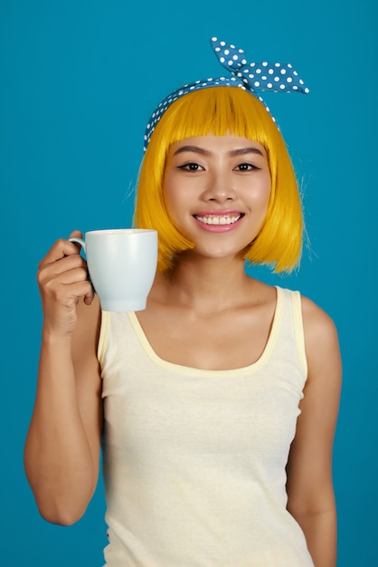 Foto grátis mulher asiática atraente na peruca brilhante, bebendo café da manhã