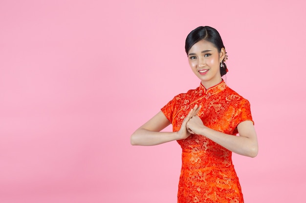 Mulher asiática bonita com gesto de parabéns no ano novo chinês