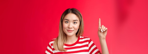 Mulher asiática bonita e amigável, com penteado loiro, usa camiseta listrada de verão sorrindo ha