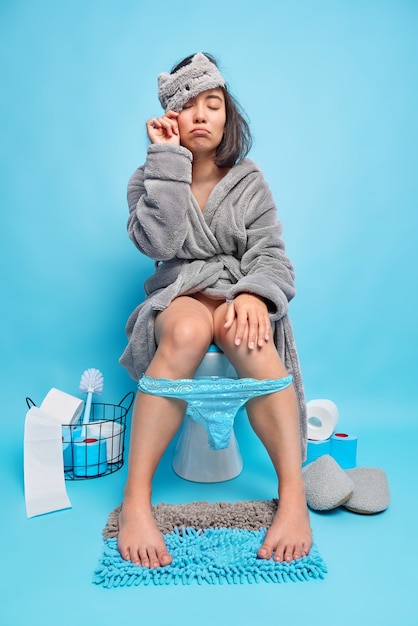 Foto grátis mulher asiática com sono acorda de manhã cedo entra no banheiro e senta no banheiro