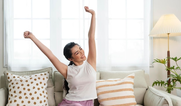 Mulher asiática de estilo de vida em casa relaxando no sofá na sala de estar