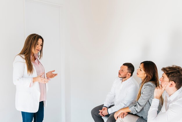 Mulher asiática fazendo apresentação na frente de colegas de trabalho