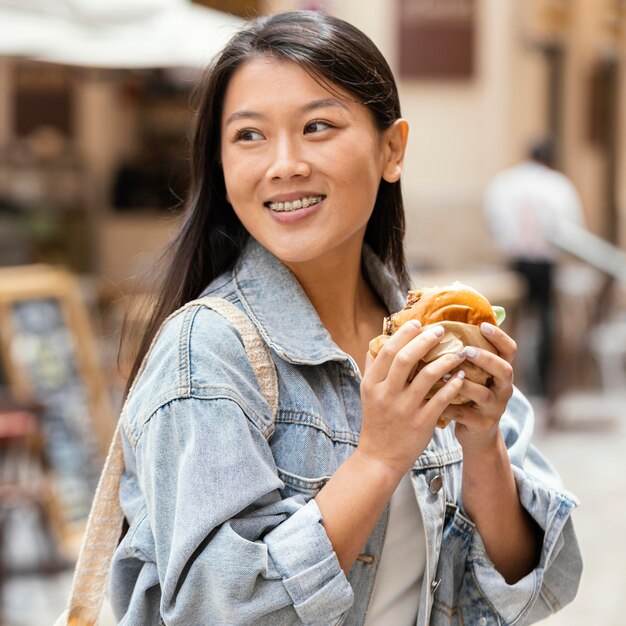 Mulher asiática feliz depois de comprar comida de rua