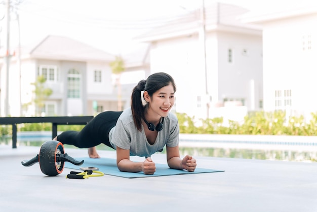 Mulher asiática feliz esticando exercícios e exercícios de ioga pela manhã em casa