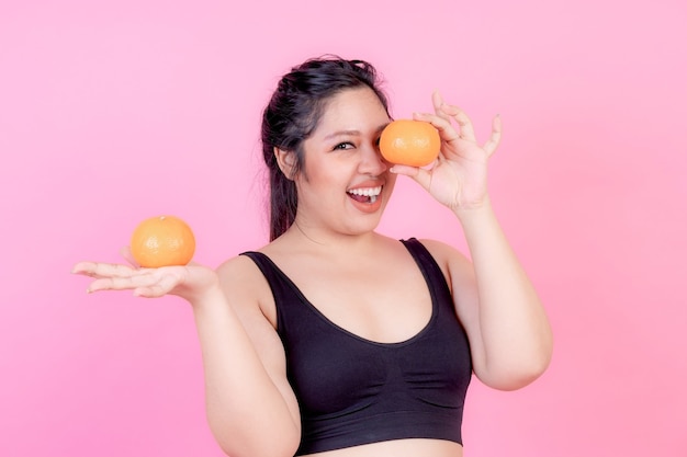 Mulher asiática gorda com excesso de peso com laranja