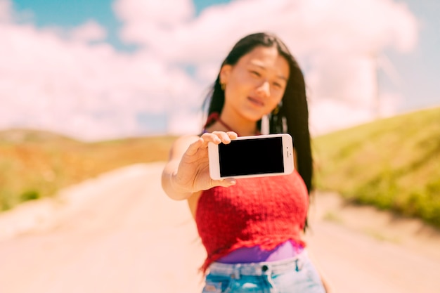 Mulher asiática mostrando smartphone com tela em branco