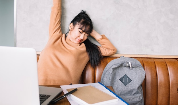 Foto grátis mulher asiática que se estende no local de trabalho