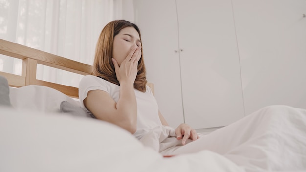 Mulher asiática sonhando enquanto dorme na cama no quarto