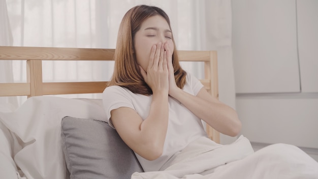 Mulher asiática sonhando enquanto dorme na cama no quarto