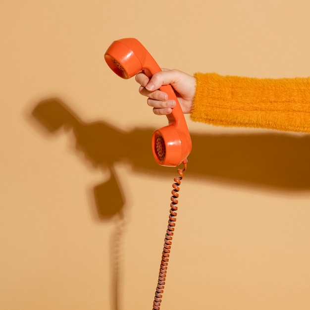 Mulher atendendo um telefone retro com fio