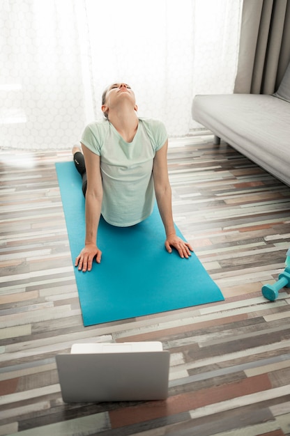 Mulher ativa, exercitando ioga em casa