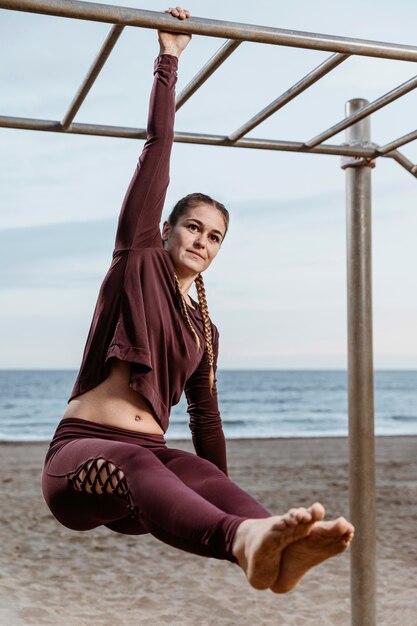 Foto grátis mulher ativa se exercitando na praia