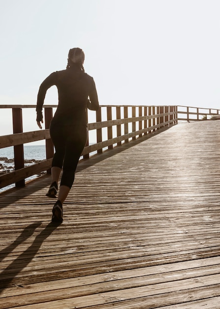 Foto grátis mulher atlética correndo na praia com espaço de cópia