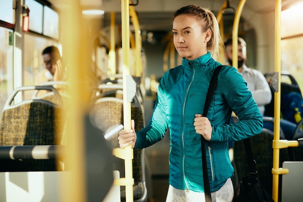 Mulher atlética viajando para treinamento esportivo de ônibus