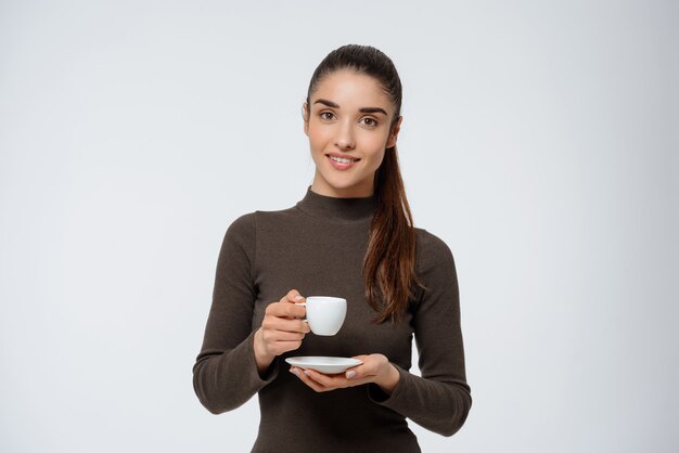 Mulher atraente, bebendo café, segurando a xícara de café expresso