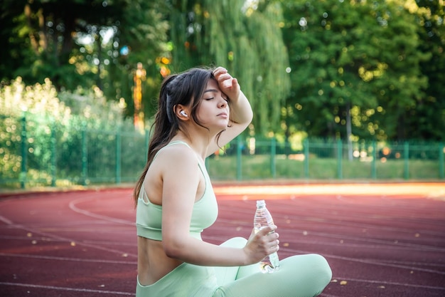 Foto grátis mulher atraente cansada depois de correr no estádio