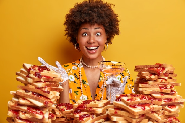 Foto grátis mulher atraente com cabelo afro cercada por sanduíches de gelatina de manteiga de amendoim