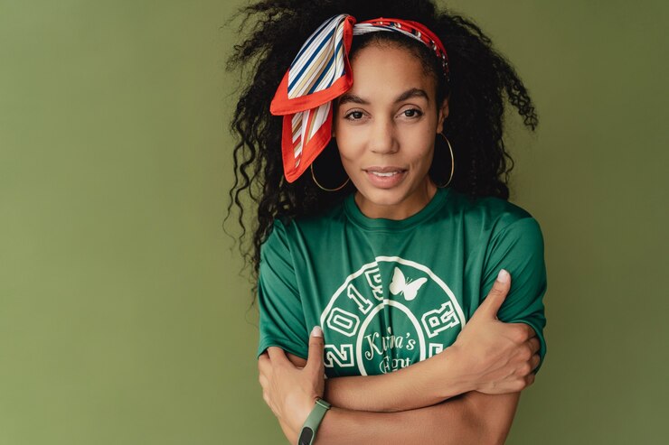 Foto grátis mulher atraente com roupa elegante hipster, camiseta e shorts na parede verde do estúdio