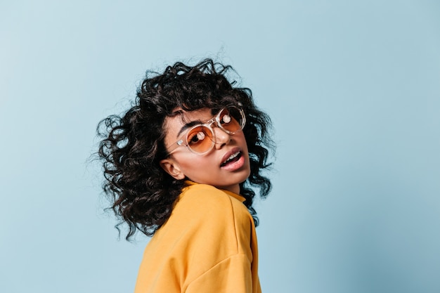 Foto grátis mulher atraente e cacheada posando de óculos escuros