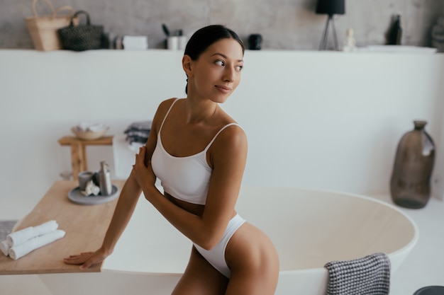Foto grátis mulher atraente em lingerie posando perto do banho. garota posando para a câmera