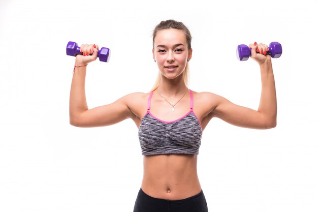 Mulher atraente fitness garota fazendo exercícios aeróbicos diferentes com halteres em branco vestida com roupas esportivas