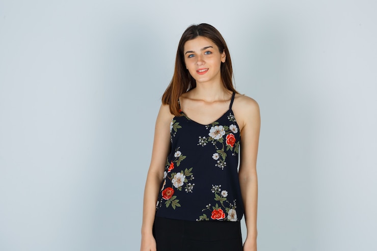 Foto grátis mulher atraente na blusa, posando em pé e olhando a vista frontal otimista.