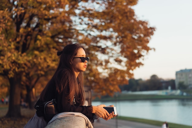 Mulher atraente usando smartphone ao ar livre no parque