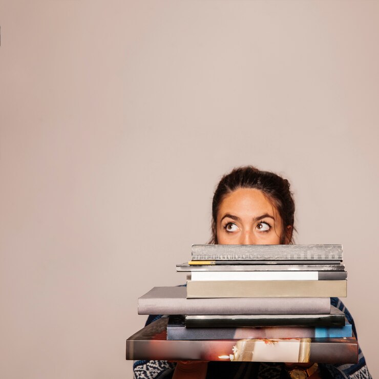 Foto grátis mulher atrás de uma pilha de livros