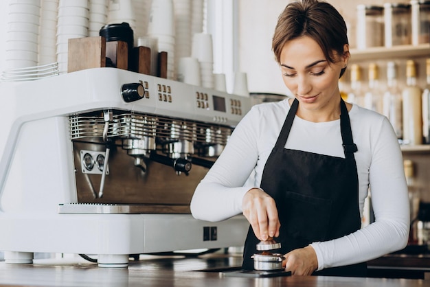 Mulher barista em uma cafeteria preparando café