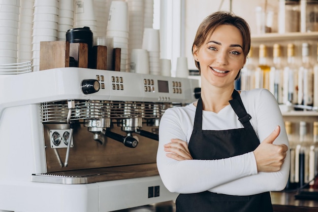 Mulher barista em uma cafeteria preparando café