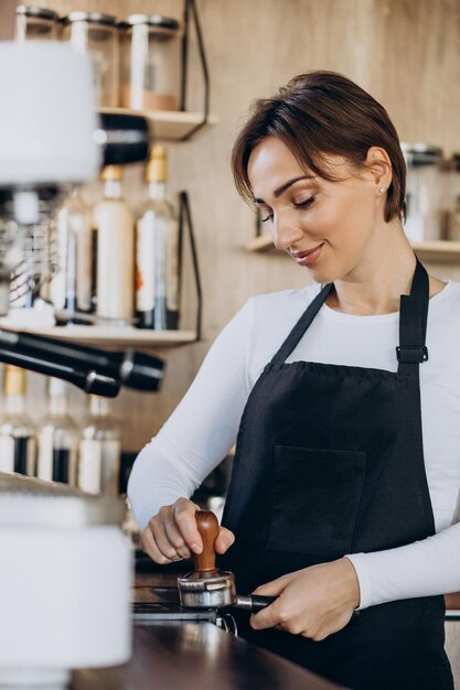 Mulher barista em uma cafeteria preparando café