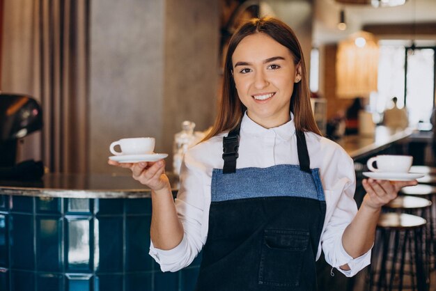 Mulher barista na cafeteria segurando café expresso