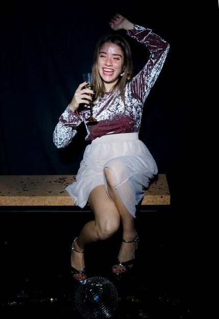 Mulher bêbada sentado no banco com uma taça de champanhe