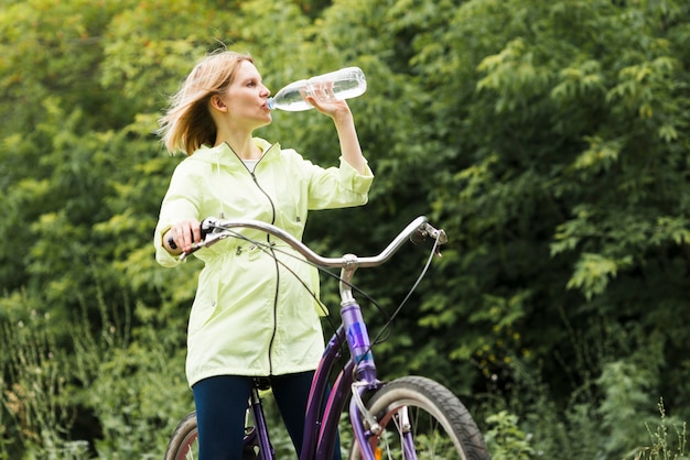 Mulher, bebendo, água, bicicleta