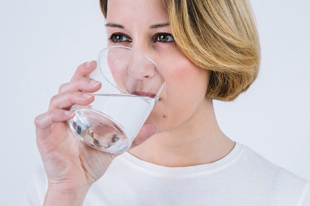 Mulher bebendo água de vidro limpa