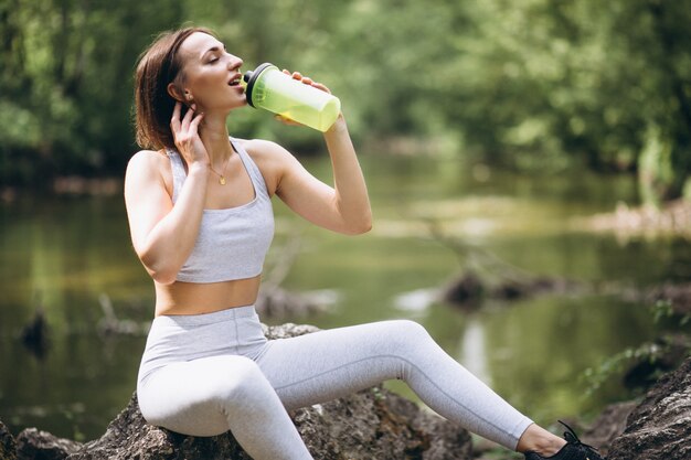 Mulher bebendo água no sportswear