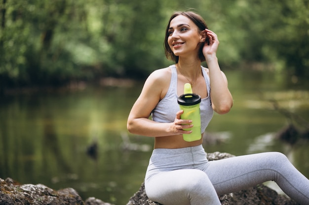 Mulher bebendo água no sportswear