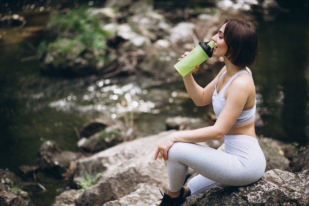 Mulher bebendo água no sportswear