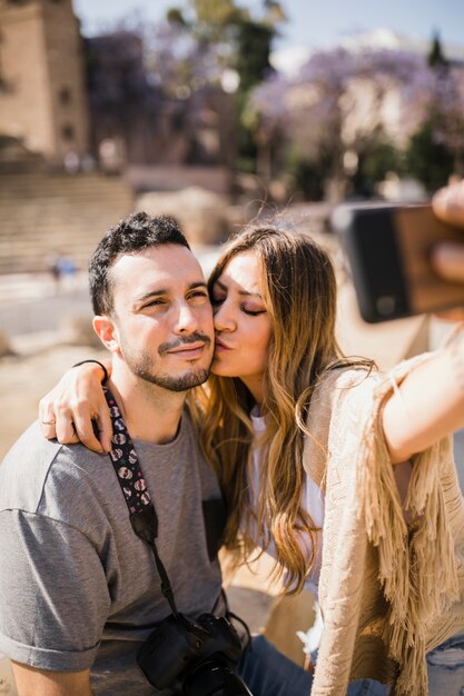 Mulher, beijando, dela, namorado, levando, selfie, ligado, smartphone